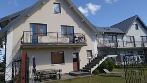 a white house with stairs and a bench in front of it at Ferienappartement Teresa in Sławoszynko