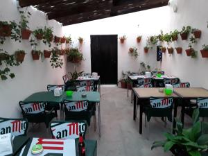 a dining room with tables and chairs and plants at Hostal Miguel in Calahonda