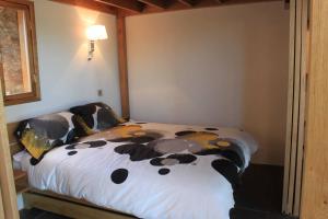 1 dormitorio con 1 cama con manta de vaca en High View Barn, en Monmouth