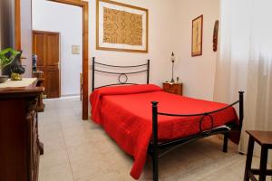 1 dormitorio con 1 cama con colcha roja en Bed & Breakfast L'Aquilino, en Iglesias