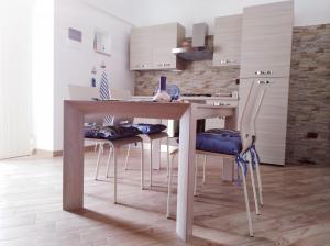 モンテ・サンタンジェロにあるLe Casette nel Rioneのキッチン(木製テーブル、椅子付)