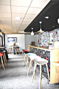 un restaurant avec des chaises, un comptoir et un bar dans l'établissement Ibis Toulouse Purpan Aeroport, à Toulouse