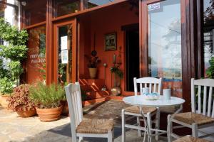 een patio met een tafel en stoelen voor een gebouw bij Cretan Village Hotel in Agios Nikolaos