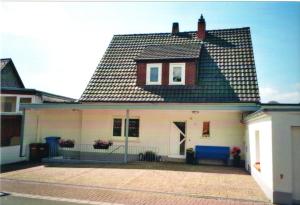 a white house with a black roof at Ferienwohnung Büttner in Solms-Oberbiel