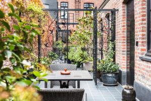 a patio with a table and chairs and plants at Main Street Hotel in Ieper