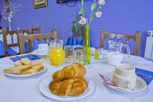 a table with croissants and bread and orange juice at Hospedería El Cantio in Oreña