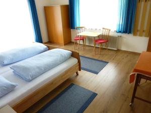 ハイリゲンブルートにあるHaus Valentinのベッド2台、テーブル、椅子が備わる客室です。