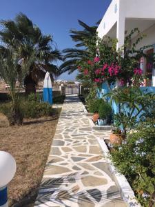 a stone walkway next to a house with flowers at Princess Studios in Afiartis