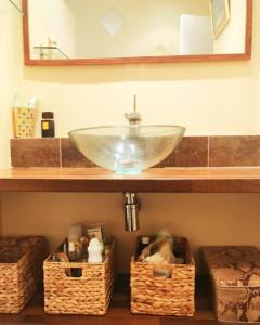 un bagno con lavandino e cestini su una mensola di Le Bosquet a Cassis