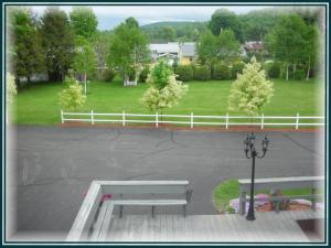 a park with two benches in a parking lot at Swift River Suites in Rumford