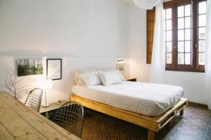 a bedroom with a bed and a table and windows at Casa Helsinki in Cordoba