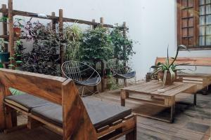 a patio with wooden benches and potted plants at Casa Helsinki in Cordoba