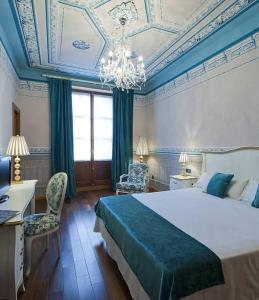 Un dormitorio con una cama grande y una lámpara de araña. en Posada Real Los Cinco Linajes, en Arévalo 37 fotos más