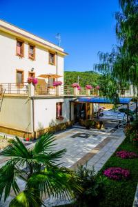 a large white building with a courtyard with flowers at Hotel Al Ritrovo in Piazza Armerina