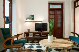 sala de estar con TV, mesa y sillas en Casa Helsinki en Córdoba
