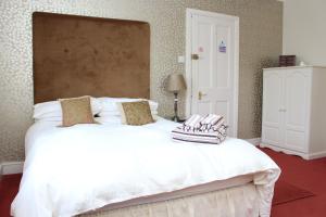 a bedroom with a bed and a dresser at Laurels Guesthouse in Witney