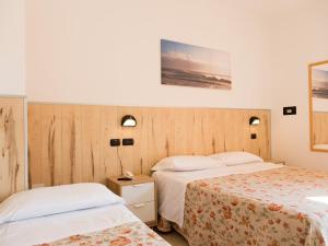 A bed or beds in a room at Hotel Saint Tropez - Pineto