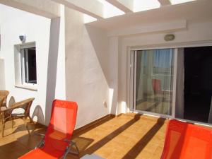 ベナルマデナにあるApartamento Terrazas del Marのバルコニー(椅子付)、窓が備わる客室です。