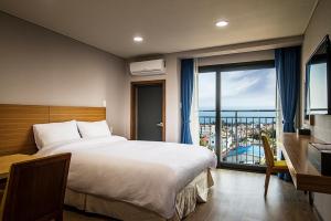 W Ocean Pension في سيوجويبو: غرفة فندقية مع سرير وشرفة
