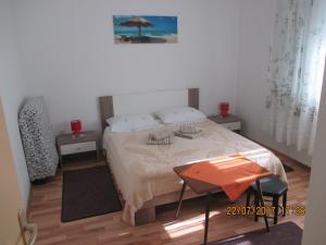 - une chambre avec un lit, une table et un parasol dans l'établissement Apartments Sandra, à Novigrad