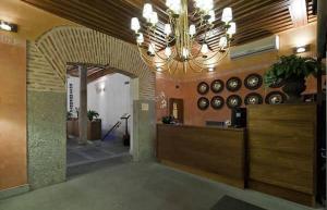 een grote lobby met een kroonluchter in een gebouw bij Posada Real Los Cinco Linajes in Arévalo