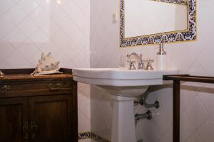 uma casa de banho com um lavatório branco e um espelho. em Casa de Pascoaes Historical House em Amarante