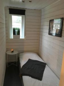 Habitación pequeña con cama y ventana en Stugcentralen Stuga 24, en Halmstad