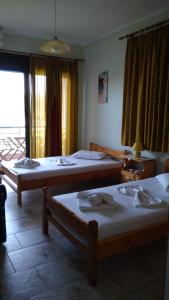 a room with two beds and a window at Nikolitsa Apartments in Glyfada Fokidas