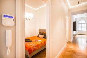 - une chambre avec un lit et une couverture orange dans l'établissement BpR Opera Lux Treasure, à Budapest