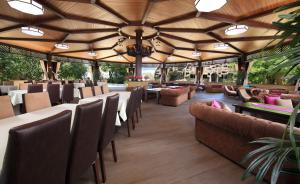 a restaurant with tables and chairs and a large ceiling at Villa Mask in Pyatigorsk