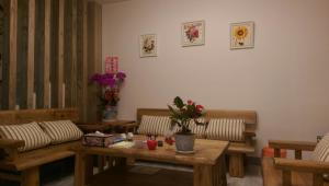 a living room with benches and a table with flowers at Time House in Hualien City