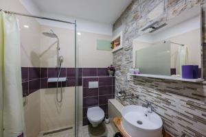 a bathroom with a shower and a sink and a toilet at Apartman Lavanda in Kaštela +29 photos