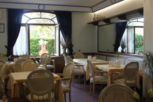 a dining room with tables and chairs and a mirror at Hotel Girasole in Civitanova Marche