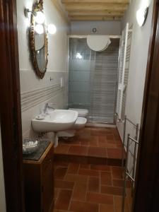 a bathroom with a sink and a toilet and a mirror at Casa Maria Teresa in San Donato in Poggio