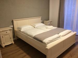 a white bed with white sheets and pillows at Provincial in Vişeu de Jos