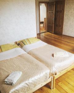 two beds in a room with wooden floors at Jolando Apartment in Kaunas