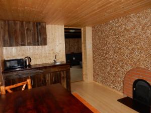 a kitchen with a stove and a brick wall at Kalda Camping Valma in Valma