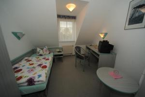 1 dormitorio con cama, escritorio y mesa en Hotel Am Markt en Sagard
