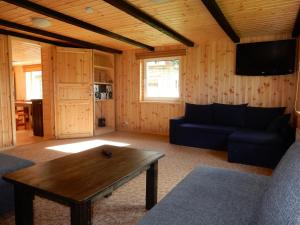 a living room with a blue couch and a table at Kalda Camping Valma in Valma