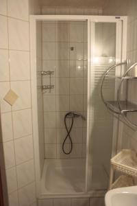 een douche met een glazen deur in de badkamer bij U Kuby in Korbielów