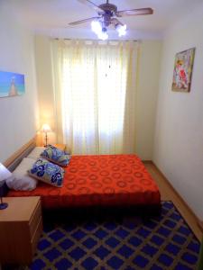 1 dormitorio con 1 cama grande de color rojo y ventana en Explanada Beach Deluxe Flat, en Alicante