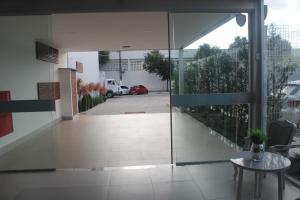 eine Glastür, die auf eine Terrasse mit einem Tisch führt in der Unterkunft Pratti Hotel in Linhares