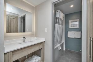 a bathroom with a sink, toilet, and bathtub at Vittoria Hotel & Suites in Niagara Falls