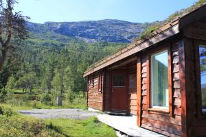 a wooden cabin with a view of a mountain at Hytte ved Gaularfjellet in Viksdalen