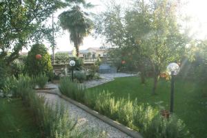 un jardin avec de l'herbe et des arbres ainsi qu'une maison dans l'établissement Bed&Breakfast degli ulivi, à Fiano Romano