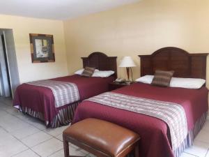 Rúm í herbergi á Alvin Extended Stay