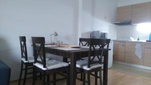 a kitchen with a table with chairs and a microwave at Donovaly AD Kamzík - apartmán 47 in Donovaly