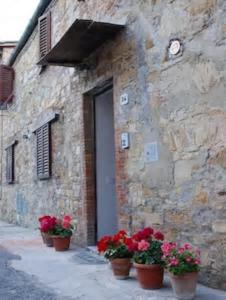 a building with pots of flowers in front of a door at Casa Maria Teresa in San Donato in Poggio