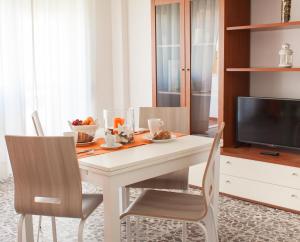 a white dining room table with two chairs and a television at Case Vacanze Ganimede in Sperlonga
