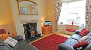 a living room with a couch and a fireplace at Sea Haven Northumberland in Seahouses